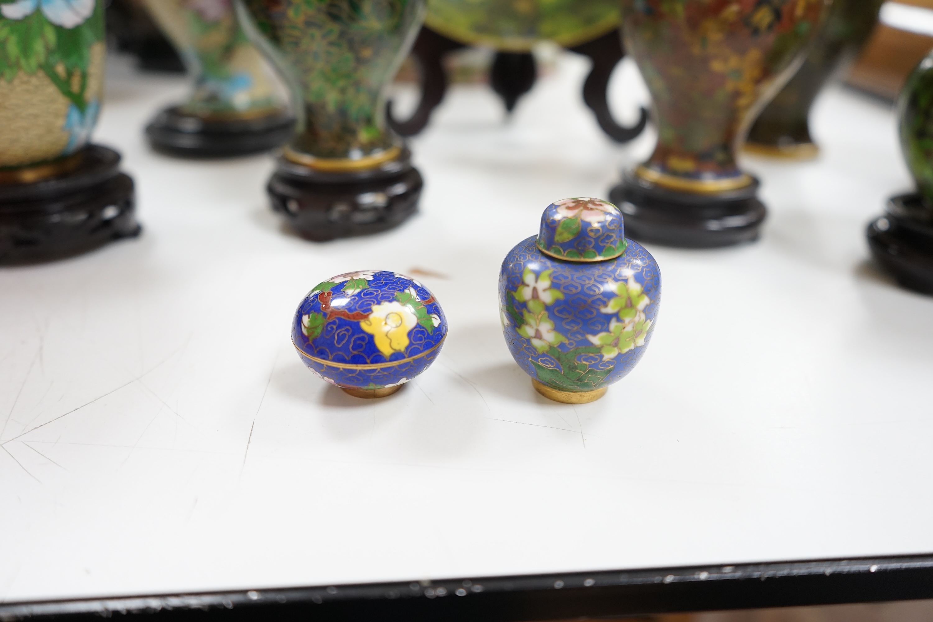 A collection of Chinese cloisonné enamel wares, with mixed coloured backgrounds, all with floral designs, some with stands, plate 21cm diameter. Condition - good